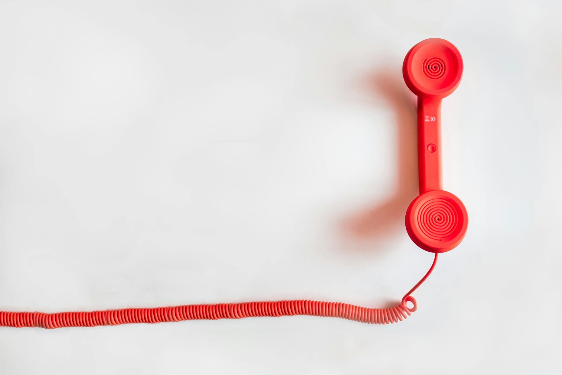 Rotes Schnurtelefon auf weißem Hintergrund